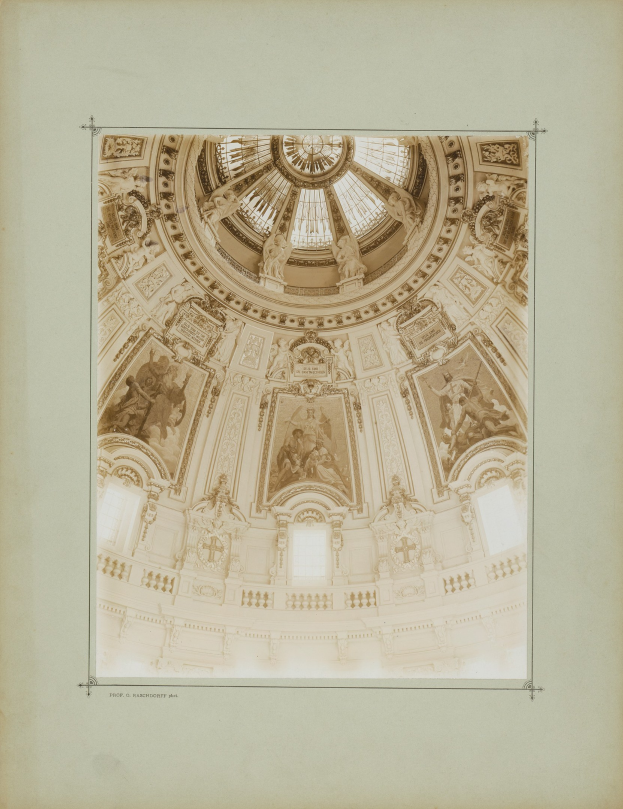 Fotografie im Rahmen eines alten Gebäudedoms mit detaillierten Entwürfen und Skulpturen an den Wänden und der Decke.