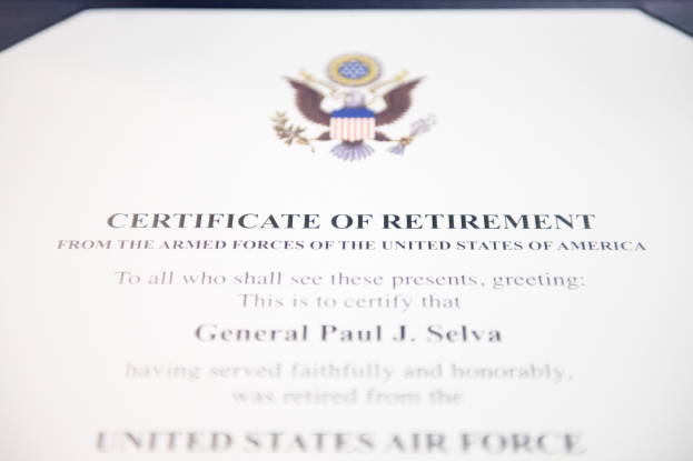 Rahmenurkunde über den Ruhestand von der United States Air Force mit blauem Rand, die ein zentrales Sternschild-Logo innerhalb eines Lorbeerkranzes und eine 'Ruhestand'-Banner zeigt, alles in Schwarz gedruckt.