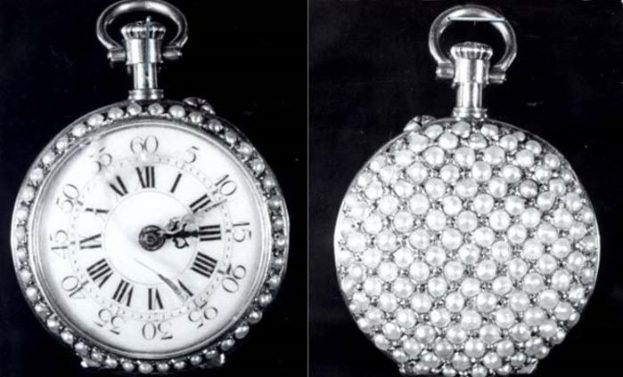 Eine silberne Taschenuhr mit Diamanten, die auf einem schwarzen Hintergrund zu sehen ist, mit einem runden Zifferblatt und römischen Ziffern sowie funkelnden Diamanten.