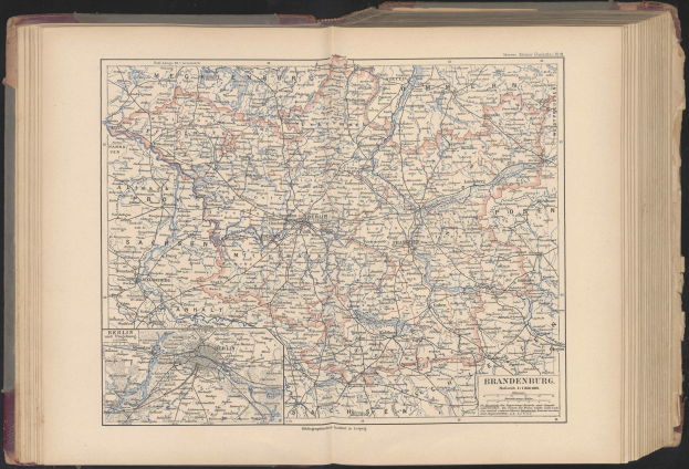 Ein aufgeschlagenes Buch, das eine detaillierte Karte von Deutschland zeigt, die Straßen, Städte und geografische Merkmale hervorhebt.