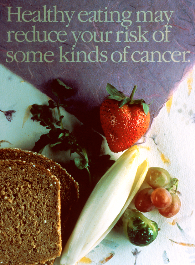 Ein Plakat mit dem Text 'Gesunde Ernährung kann Ihr Risiko für bestimmte Krebsarten reduzieren' und Abbildungen von einem Brotstück, einer Erdbeere und ein paar Trauben.