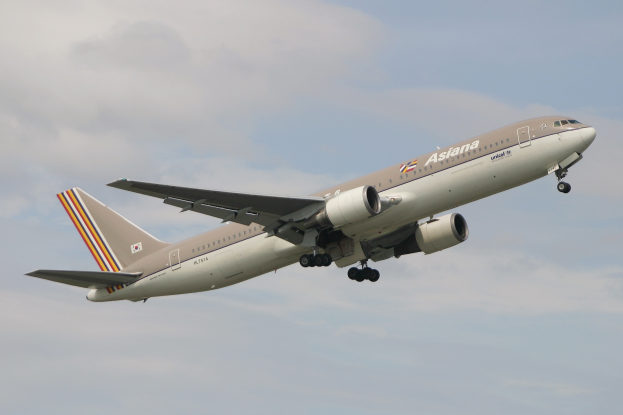 Ein Airbus A330-300 der Asia Airlines fliegt am Himmel mit weißen, flauschigen Wolken im Hintergrund, ausgebreitete Flügel und sichtbare Triebwerke.