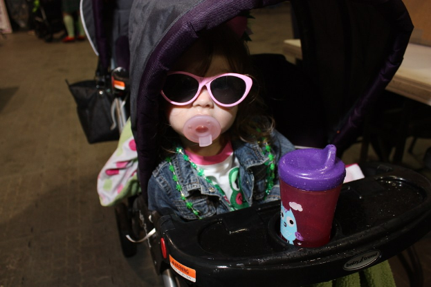 Ein Kind sitzt in einem Laufgänger, der auf der Straße positioniert ist.