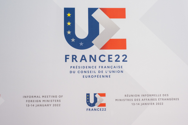 Ein Plakat mit dem Text 'Frankreich 22 - Informelles Treffen der Außenminister' und dem Logo der Europäischen Union, das ein blauer Kreis mit einem weißen Rand, einem weißen Stern in der Mitte und einem weißen Rand ist.