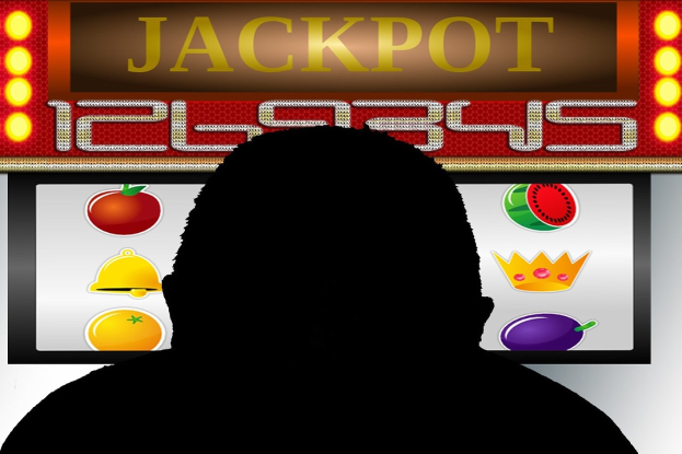Mann spielt einen einarmigen Banditen mit "Jackpot" auf dem Display, umgeben von einer Tafel mit Text und Fruchtbildern, die ein Online-Casinospiel anzeigen.