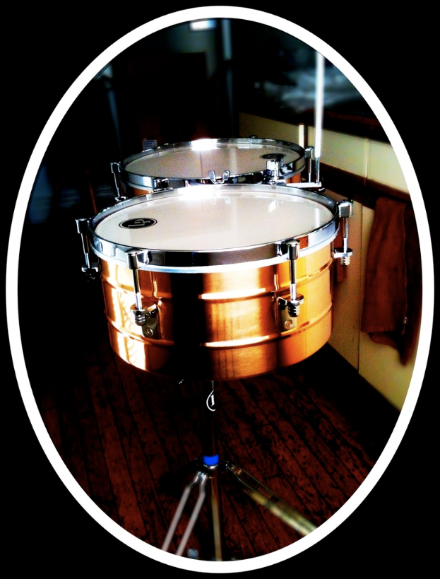 Eine Sammlung von Musikinstrumenten, darunter eine Gitarre, ein Saxophon und ein Schlagzeug, auf einem h├Âlzernen Boden angeordnet.