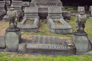 Ein Friedhof mit zahlreichen Grabsteinen, darunter einige mit der Inschrift "John Louis Schaffer", umgeben von Gras und Bäumen.