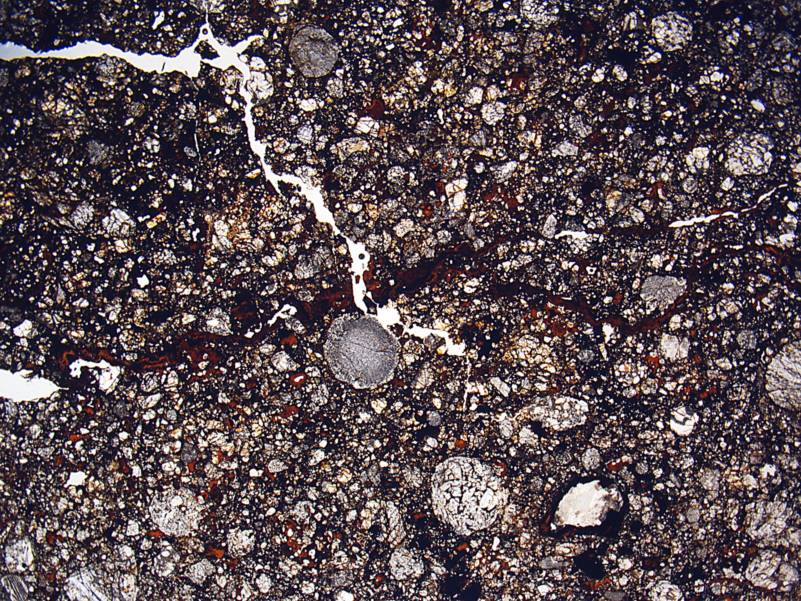 Nahaufnahme einer rissigen, schmutzigen Straße mit einer rauen, unebenen Oberfläche.