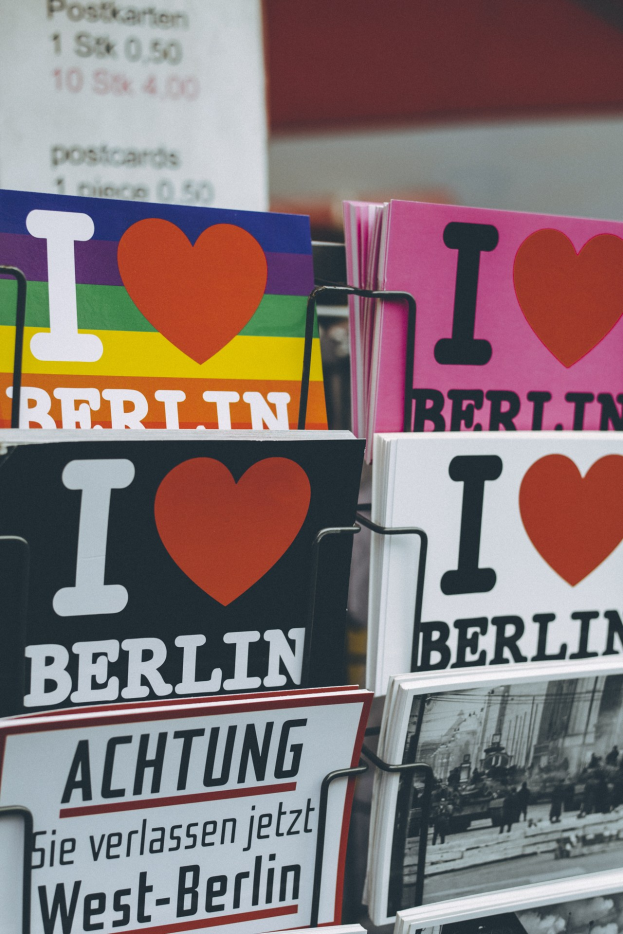 Ein Displayständer mit Büchern und Postern, die den Text 'Ich liebe Berlin' zeigen, vor einem sanft unscharfen Hintergrund.
