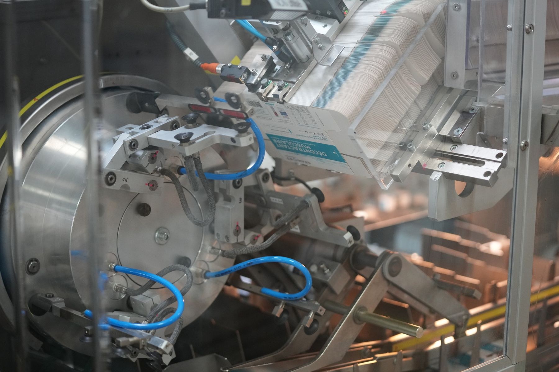 Automatisiertes Verpackungssystem auf einem Fabriktisch mit leicht unscharfen Hintergrundobjekten.