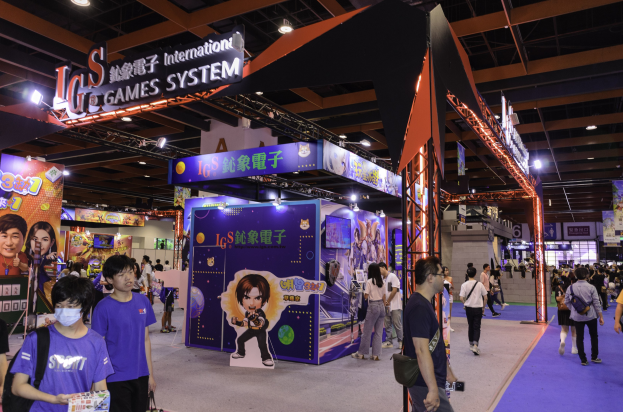 Eine Gruppe von Menschen geht durch einen Kongresssaal mit Ständen, trägt Taschen und hält Gegenstände, mit vielen anderen im Hintergrund auf einer Spielemesse in China.