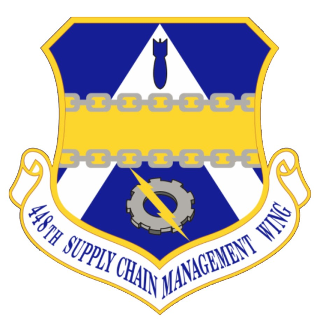 Logo des 48. Versorgungsgeschwader mit einem blauen Schild mit einem weißen Stern und einem weißen Banner mit der Aufschrift "Versorgungsgeschwader" in blau, alles von einem weißen Rand und schwarzer Schrift umgeben.