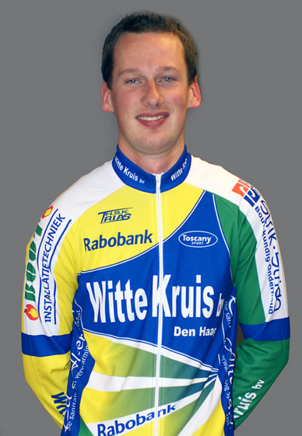 Ein Sportler posiert für ein Foto und trägt ein Trikot mit verschiedenen Sponsorennamen.