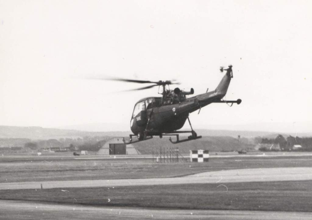 Ein Hubschrauber fliegt in der Luft mit mehreren EisenstÃ¤ben darunter.
