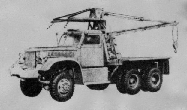 Ein Schwarz-Weiß-Foto eines großen, vierrädrigen Lkw mit einem Kran auf der Rückseite und einem flachen Anhänger