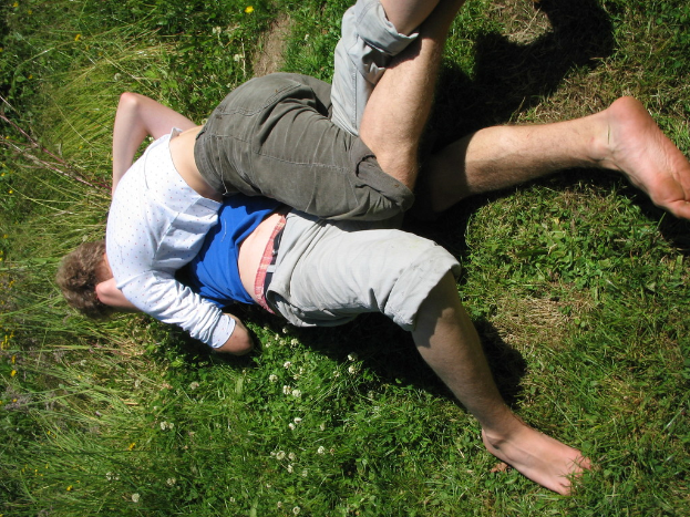Zwei Personen kämpfen auf einer Grasfläche.